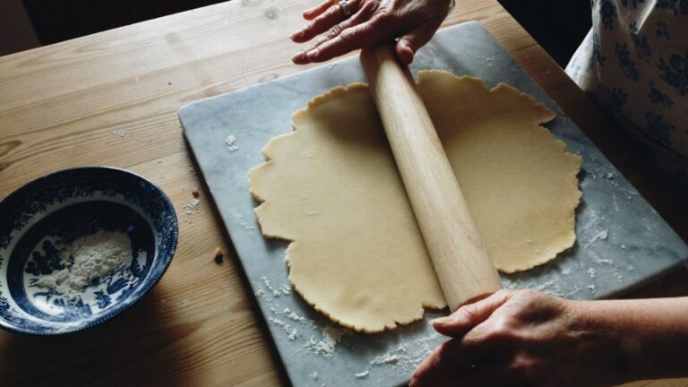 A batch of perfectly shaped, unspread sugar cookies on a baking sheet, ready for decorating.