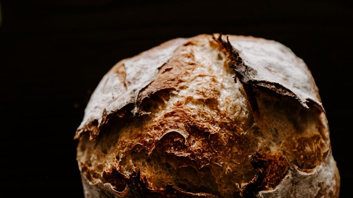 A close-up of active dry yeast blooming in warm water, showing a foamy, bubbly surface, indicating its readiness for baking.