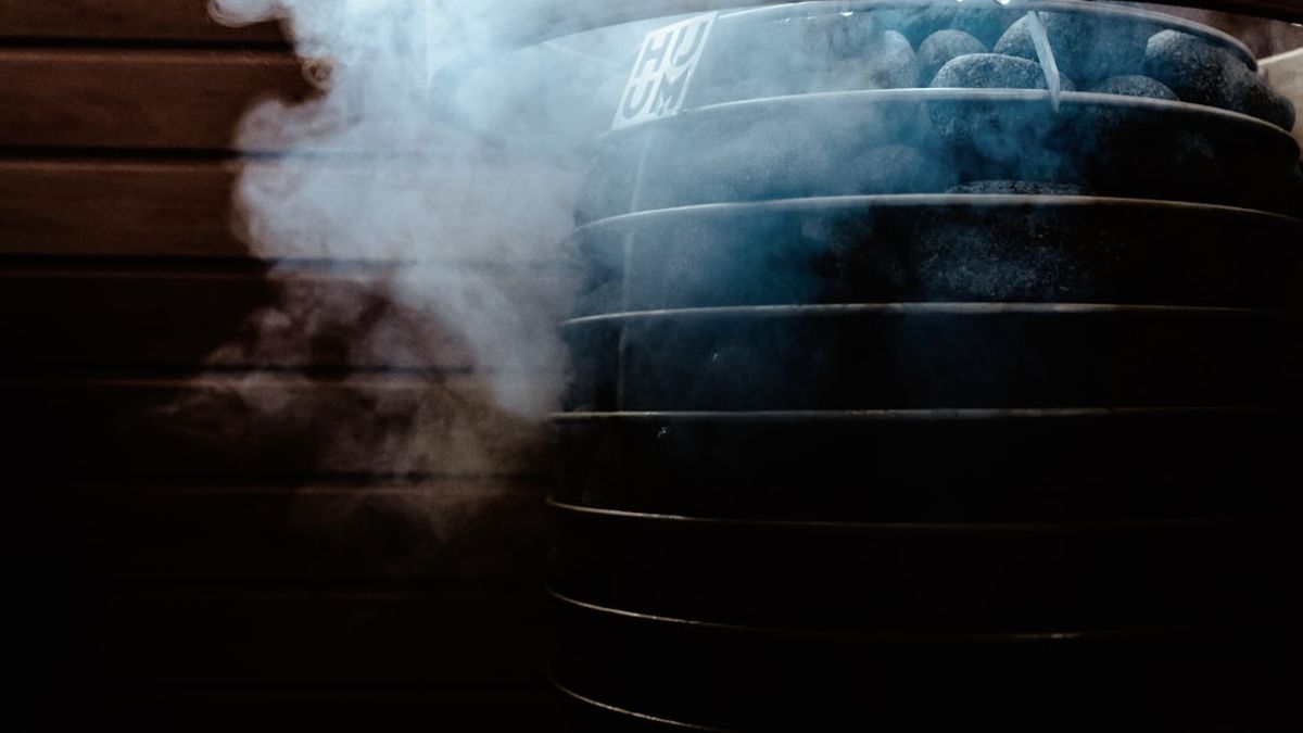 A close-up shot of crispy, golden-brown chicken thighs in an air fryer basket, with steam gently rising, set in a bright, modern kitchen.