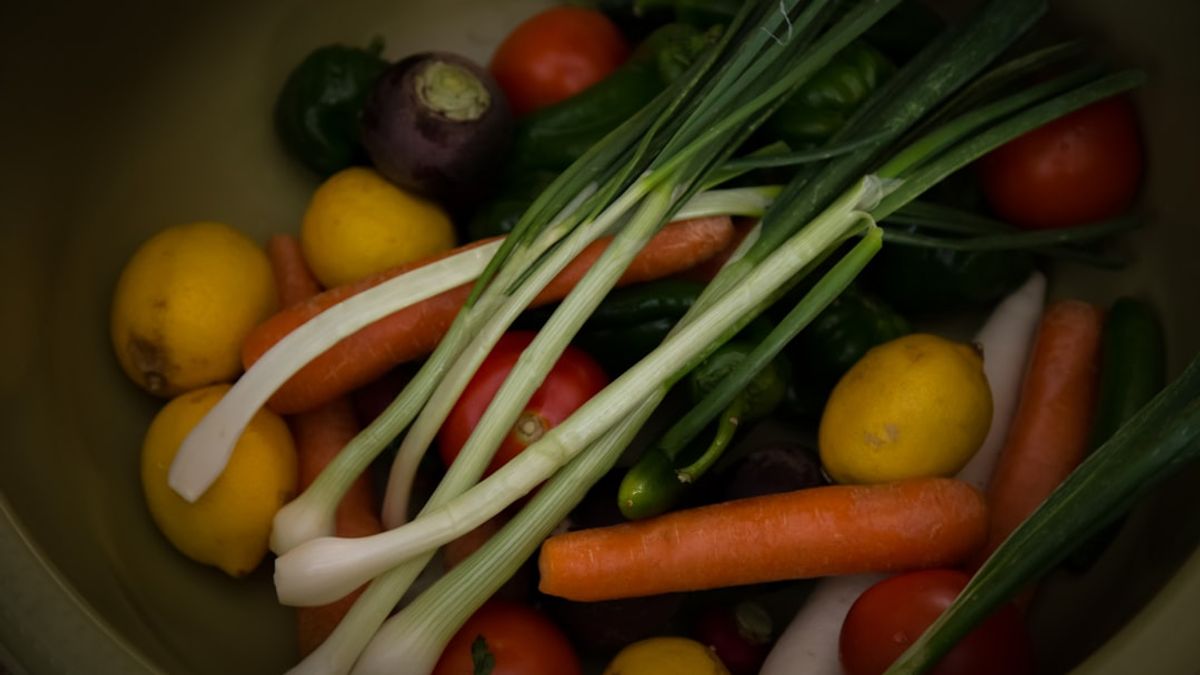 A close-up shot of perfectly golden-brown, crispy roasted broccoli florets and carrot sticks on a baking sheet, with a hint of char and glistening oil, ready to be served.