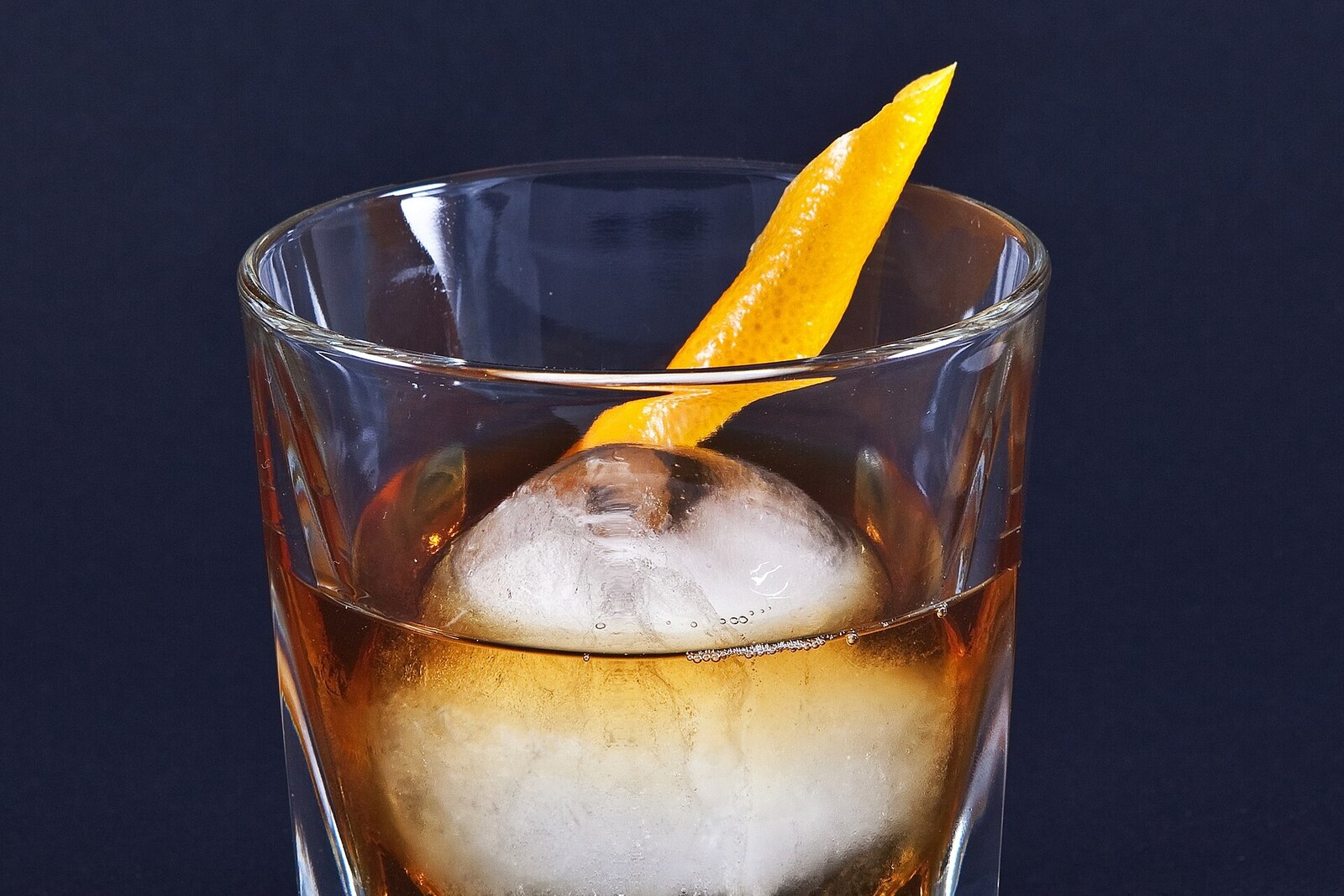 Non-alcoholic old fashioned mocktail with orange peel and cherry in rocks glass