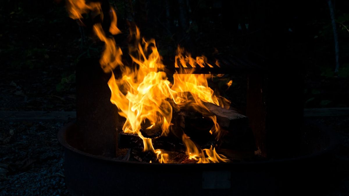 Clay ovens and cast iron pots used in historical cooking techniques, with glowing embers beneath them