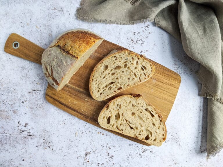 Sliced moist banana bread with walnuts on a wooden cutting board