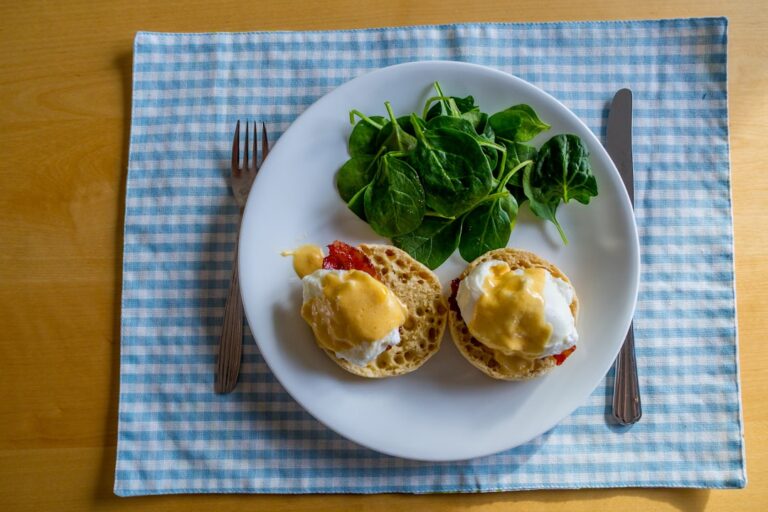 Classic eggs Benedict with hollandaise sauce dripping over poached eggs on toasted English muffins