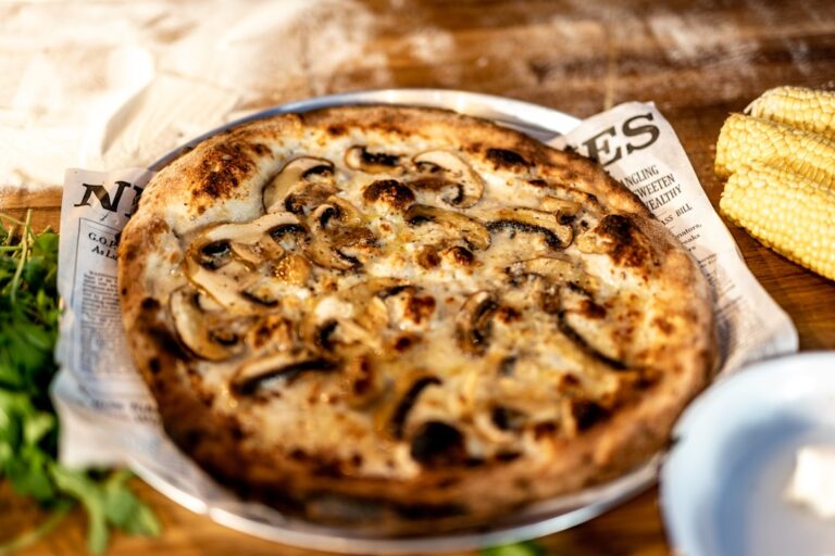 Homemade Margherita pizza with fresh mozzarella basil and charred crust on a wooden board