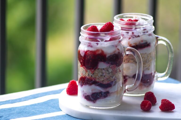 Five mason jars of overnight oats with different toppings including berries banana and chocolate