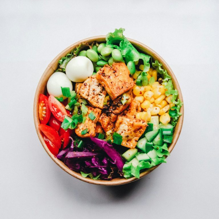 A colorful Mediterranean grain bowl with crispy roasted chickpeas golden cauliflower florets fresh greens and a drizzle of creamy lemon tahini dressing