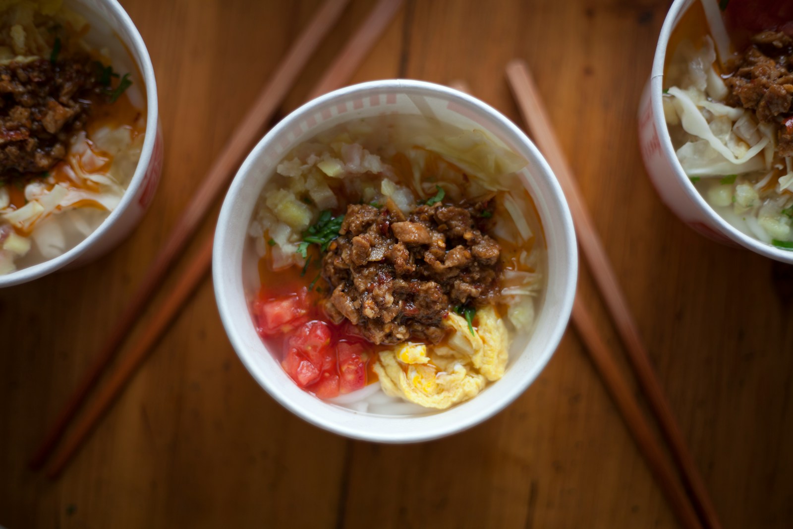 A deep bowl of smooth white Cantonese congee topped with quartered century egg, a mound of pork floss, julienned ginger, and a drizzle of scallion oil