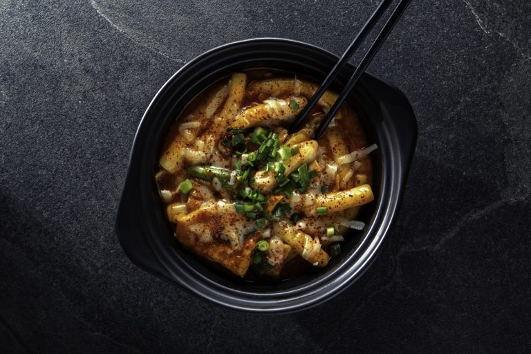 Tteokbokki crispy chewy Korean rice cakes coated in spicy red gochujang sauce