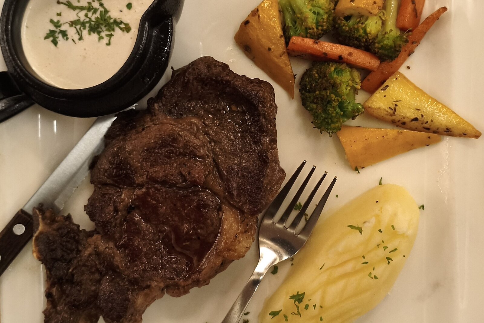 Bone-in tomahawk ribeye steak with compound butter melting on top