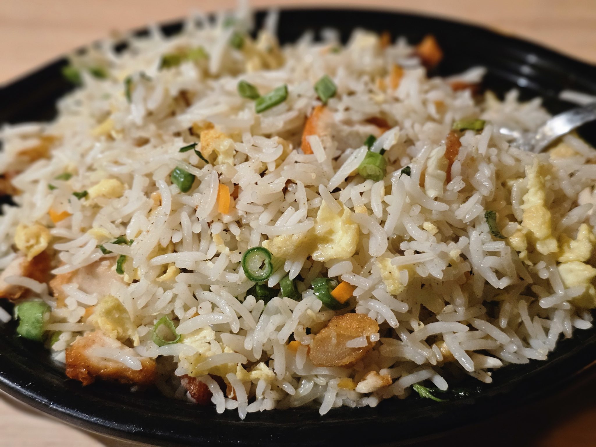 Diced onion, carrot and celery in three separate piles on a wooden cutting board