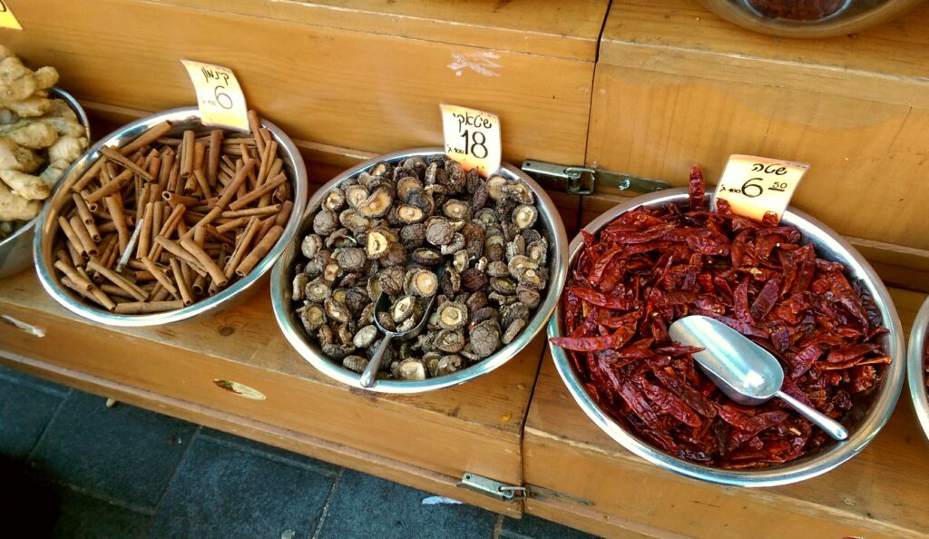 Dried shiitake mushrooms in a shallow bowl beside a small grinder on a counter