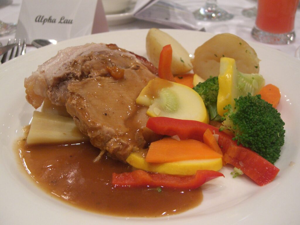 Slices of roast pork with faintly pink centers fanned across a carving board