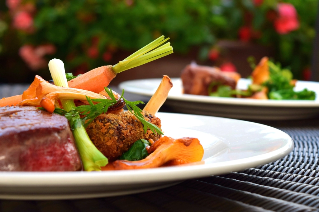 Carrot coins and onion wedges browned unevenly on a metal sheet pan