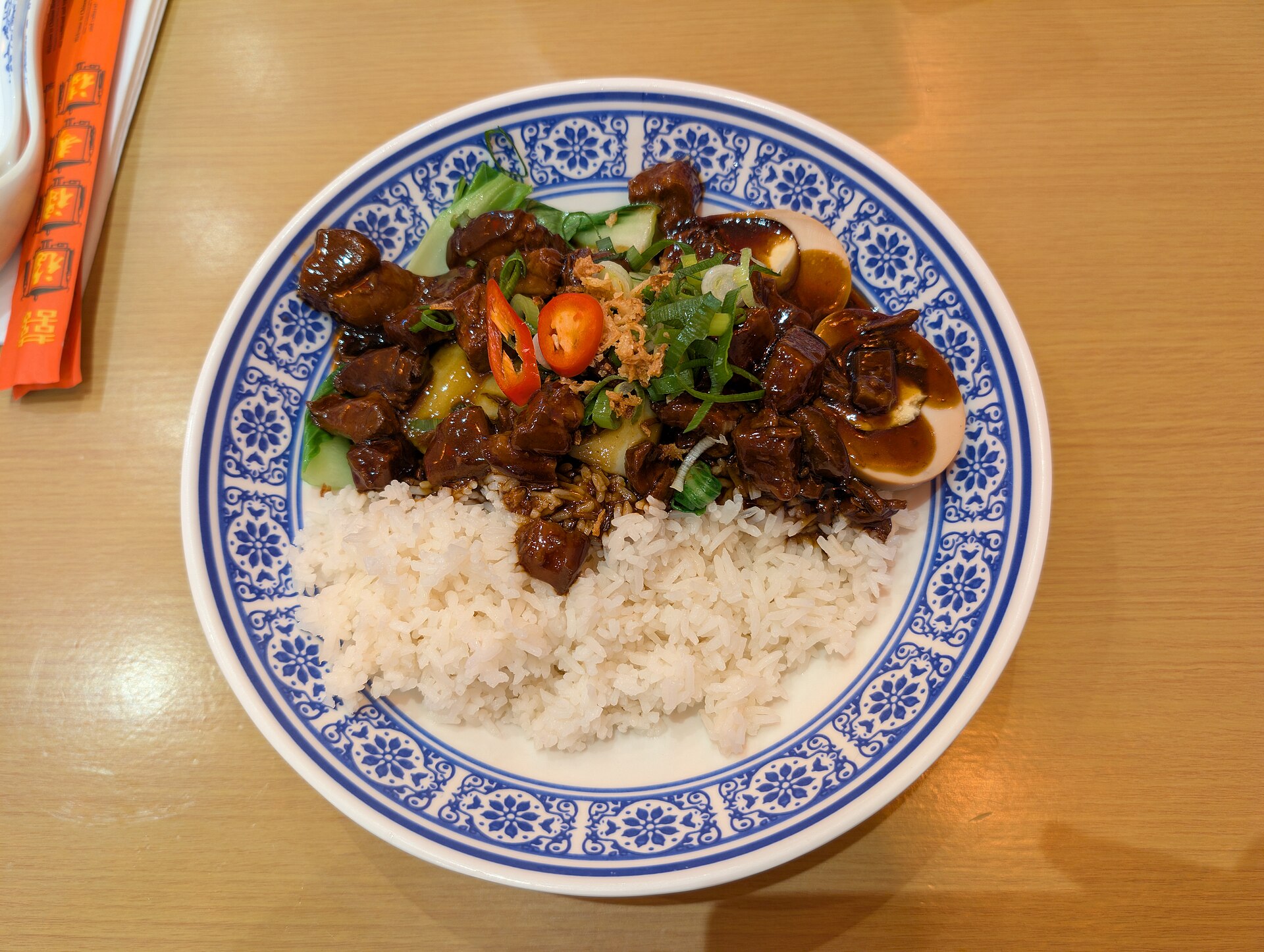 A heavy pot of browned pork shoulder pieces with onions and a shallow layer of amber liquid