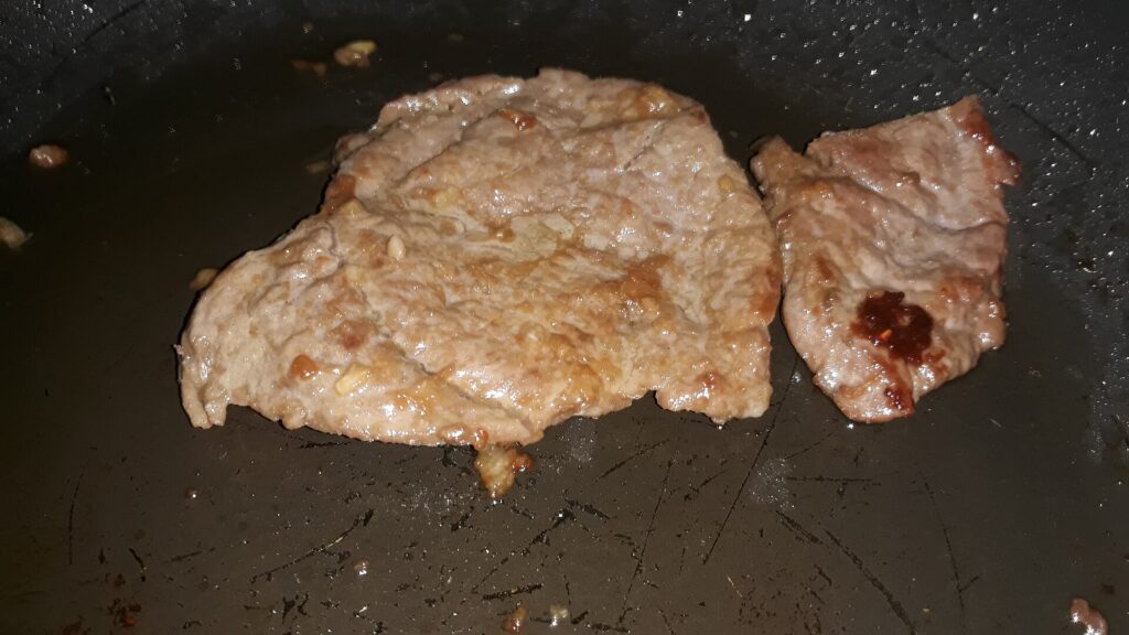 A thick steak searing hard in a smoking cast iron pan with butter and thyme