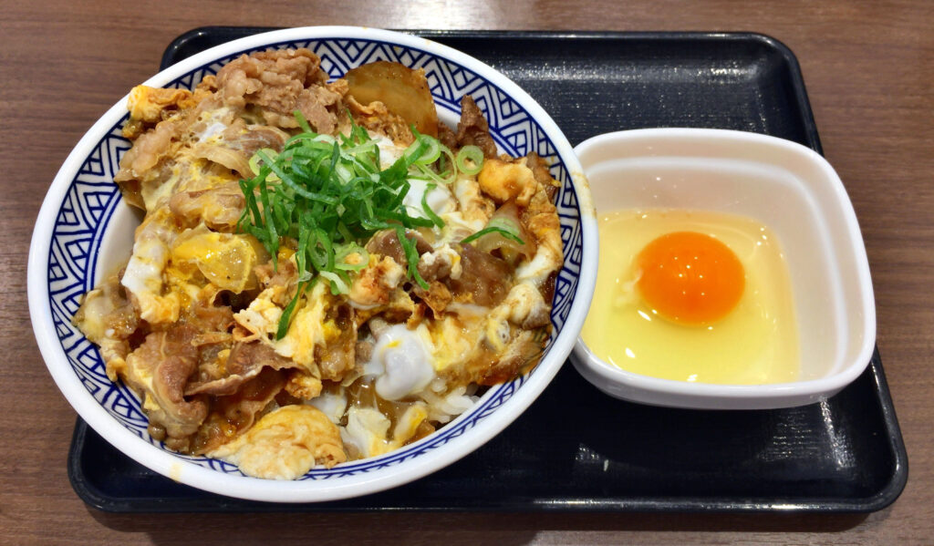 Eggs beaten smooth in a glass bowl with a fork resting against the side