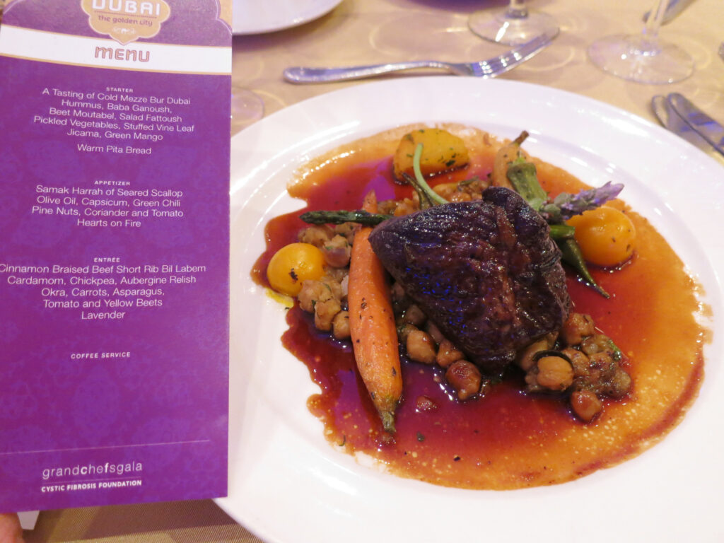 Finished braised beef and carrots in a wide pot with a glossy dark sauce