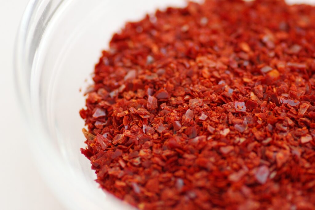 A bowl of thick red Korean chile paste with garlic and scallion mixed in