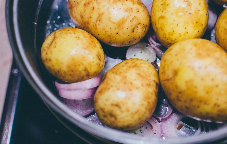 Wooden crates of unwashed potatoes and onions stored apart in a cool dim room