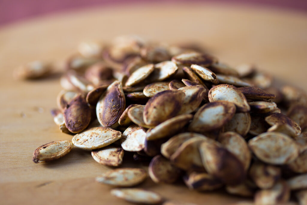 Golden roasted seeds spread in a single layer across a lined baking tray