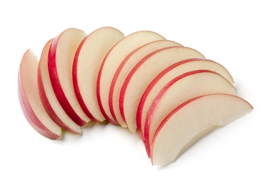 Peeled apple wedges tossed with sugar draining in a colander over a bowl